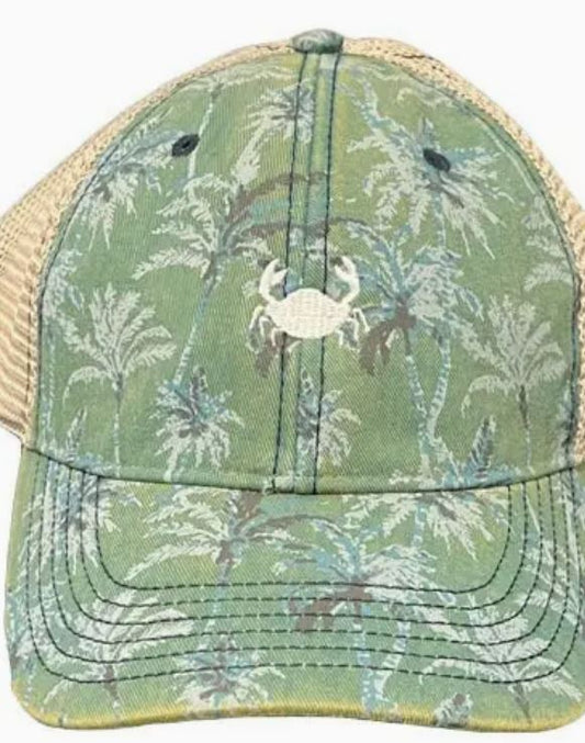 A trucker-style cap with a green camouflage pattern featuring fern motifs and a front beige mesh panel, adorned with a crab emblem in the center.